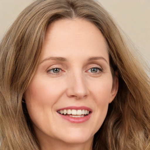 Joyful white young-adult female with long  brown hair and green eyes