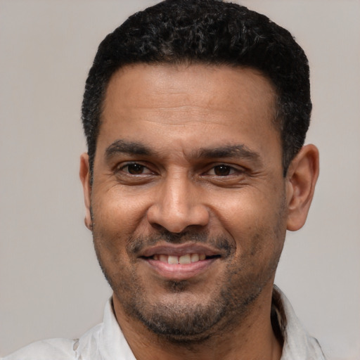Joyful latino adult male with short  black hair and brown eyes