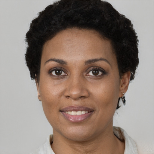 Joyful black young-adult female with short  brown hair and brown eyes