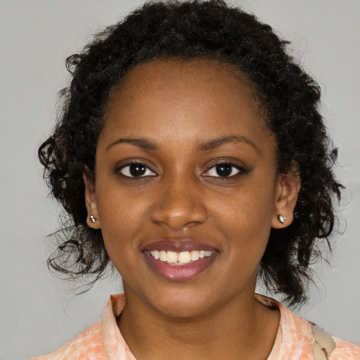 Joyful black young-adult female with medium  black hair and brown eyes