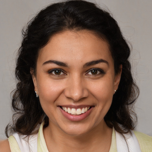 Joyful latino young-adult female with medium  brown hair and brown eyes