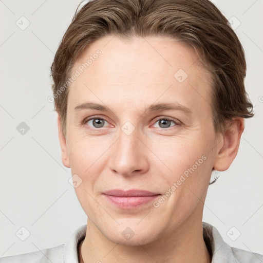 Joyful white young-adult female with short  brown hair and grey eyes