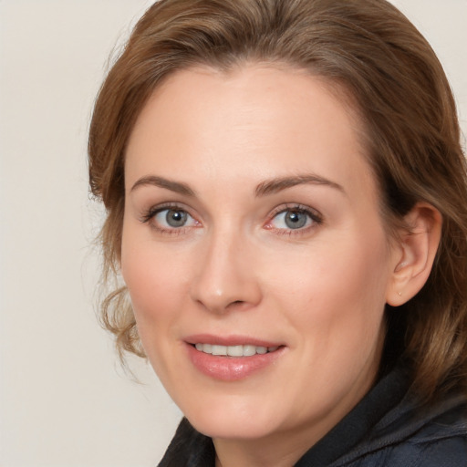 Joyful white adult female with medium  brown hair and grey eyes