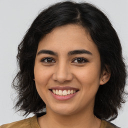 Joyful latino young-adult female with long  brown hair and brown eyes