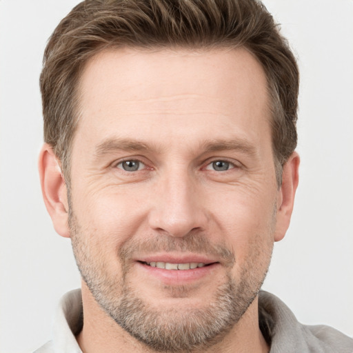 Joyful white adult male with short  brown hair and grey eyes