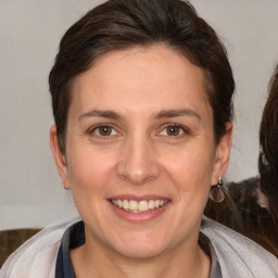 Joyful white adult female with medium  brown hair and brown eyes