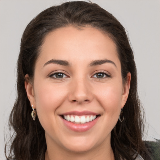 Joyful white young-adult female with long  brown hair and grey eyes