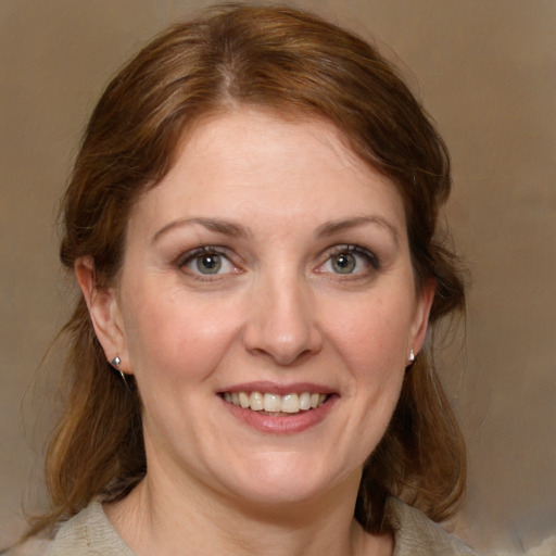 Joyful white adult female with medium  brown hair and blue eyes