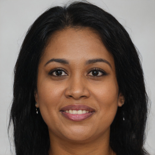 Joyful black young-adult female with long  brown hair and brown eyes
