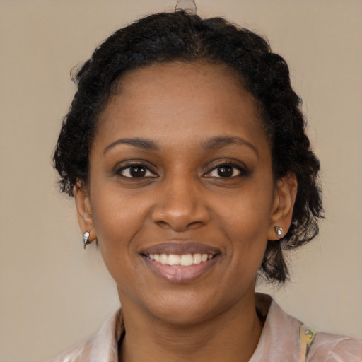 Joyful black young-adult female with medium  brown hair and brown eyes