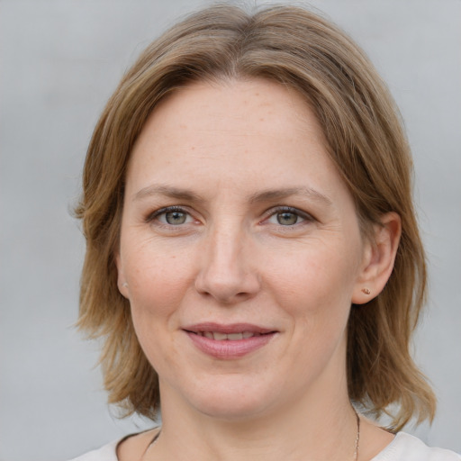 Joyful white adult female with medium  brown hair and grey eyes