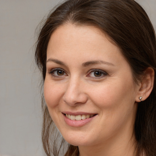 Joyful white young-adult female with long  brown hair and brown eyes