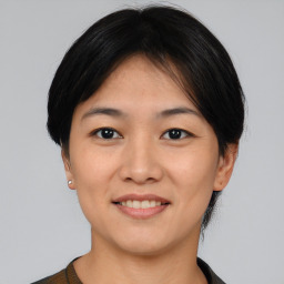 Joyful asian young-adult female with short  black hair and brown eyes