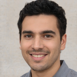 Joyful white young-adult male with short  black hair and brown eyes