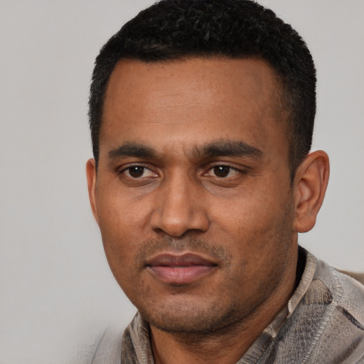 Joyful latino adult male with short  black hair and brown eyes