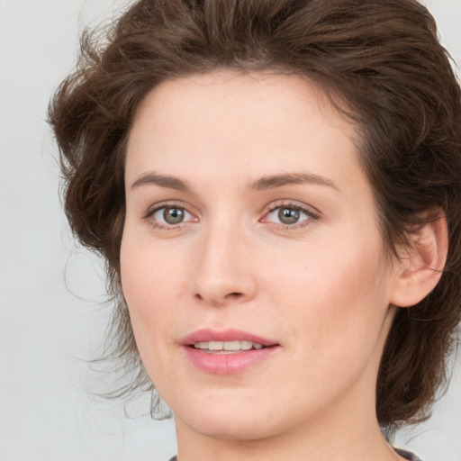 Joyful white young-adult female with medium  brown hair and green eyes