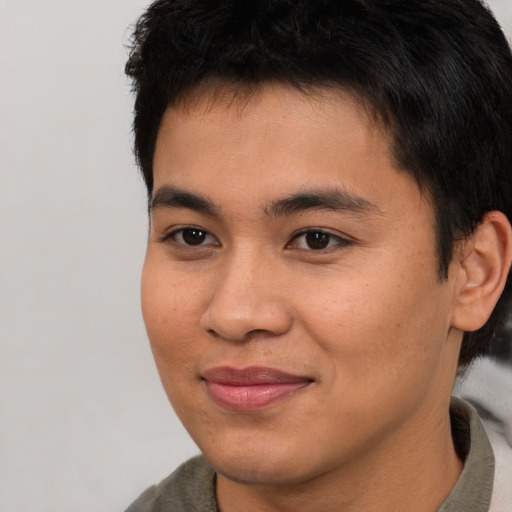 Joyful asian young-adult male with short  brown hair and brown eyes