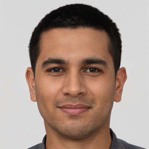 Joyful latino young-adult male with short  black hair and brown eyes