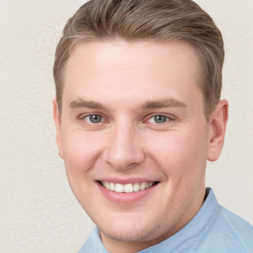 Joyful white young-adult male with short  brown hair and blue eyes