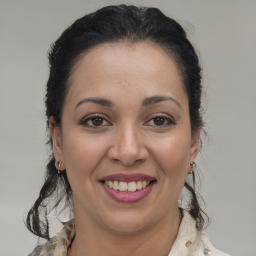 Joyful latino young-adult female with medium  brown hair and brown eyes