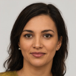 Joyful latino young-adult female with medium  brown hair and brown eyes