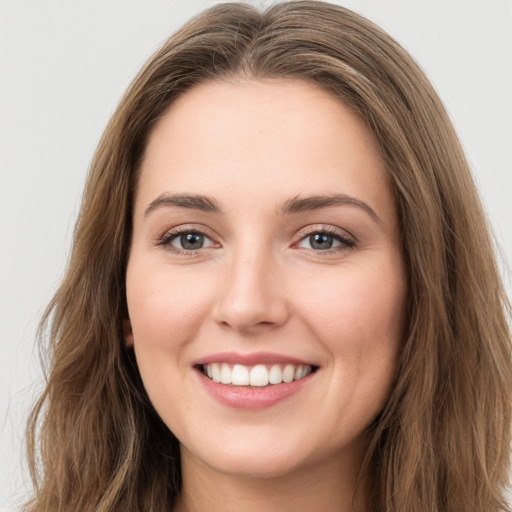 Joyful white young-adult female with long  brown hair and green eyes