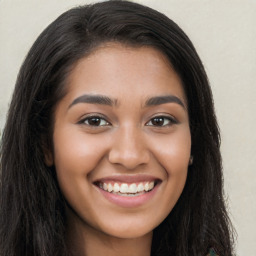 Joyful latino young-adult female with long  brown hair and brown eyes