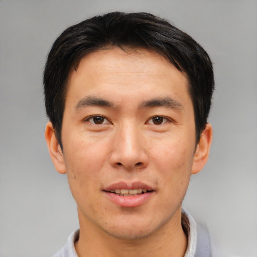 Joyful asian adult male with short  brown hair and brown eyes