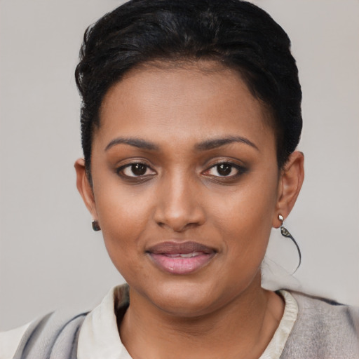 Joyful black young-adult female with short  black hair and brown eyes