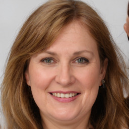 Joyful white adult female with long  brown hair and grey eyes