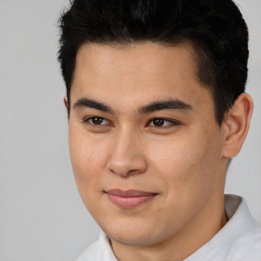 Joyful latino young-adult male with short  brown hair and brown eyes
