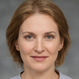 Joyful white adult female with medium  brown hair and grey eyes