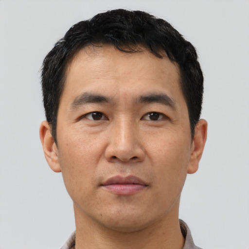 Joyful asian adult male with short  black hair and brown eyes