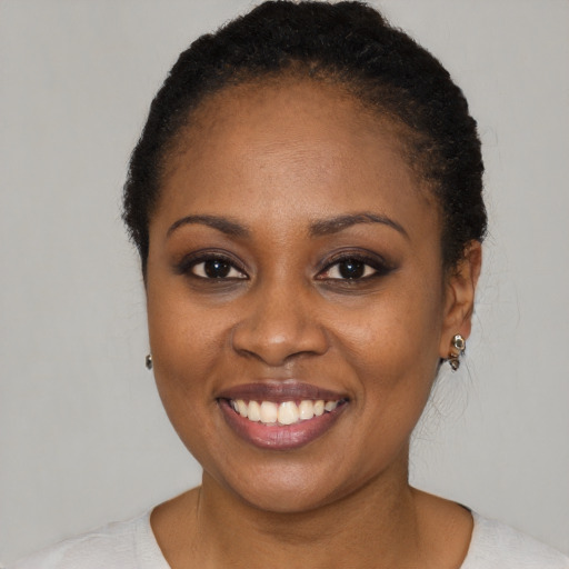Joyful black young-adult female with short  black hair and brown eyes