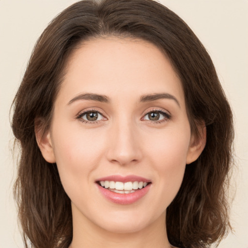 Joyful white young-adult female with medium  brown hair and green eyes