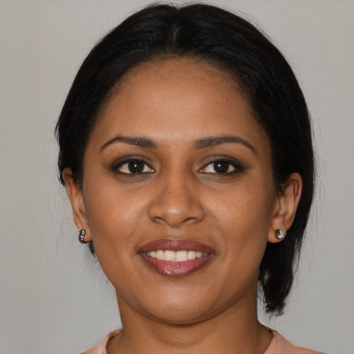 Joyful black young-adult female with medium  brown hair and brown eyes