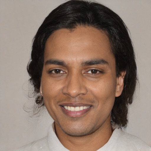 Joyful black young-adult male with medium  brown hair and brown eyes