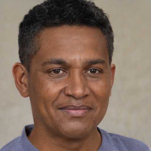 Joyful black adult male with short  brown hair and brown eyes