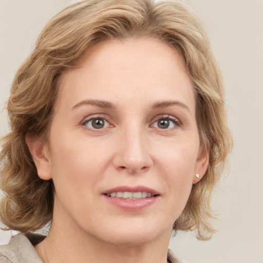 Joyful white adult female with medium  brown hair and blue eyes