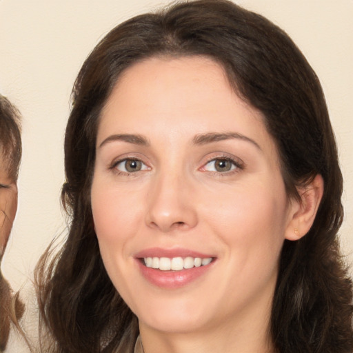 Joyful white young-adult female with long  brown hair and brown eyes