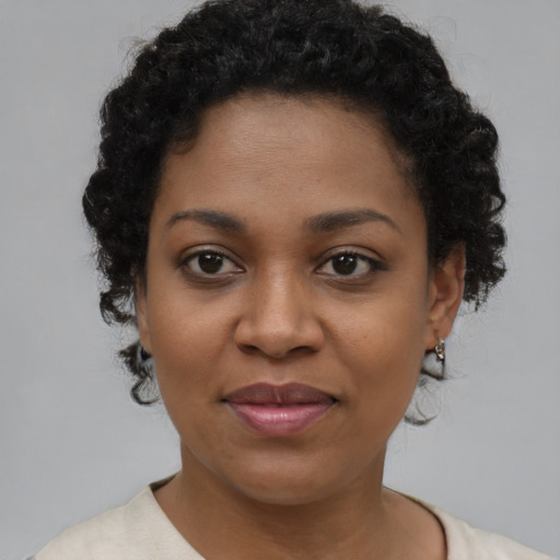 Joyful black young-adult female with short  brown hair and brown eyes