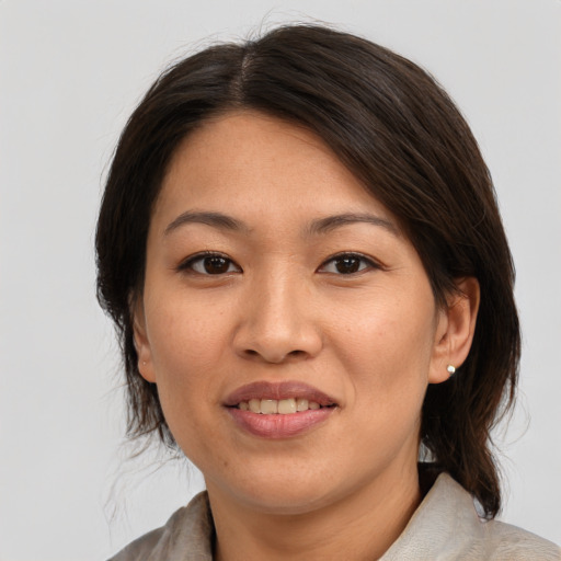 Joyful asian young-adult female with medium  brown hair and brown eyes