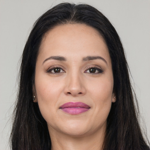 Joyful latino young-adult female with long  brown hair and brown eyes