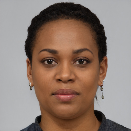 Joyful black young-adult female with short  black hair and brown eyes