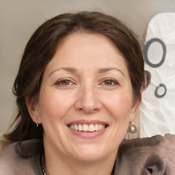 Joyful white adult female with medium  brown hair and grey eyes