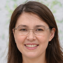 Joyful white adult female with long  brown hair and brown eyes