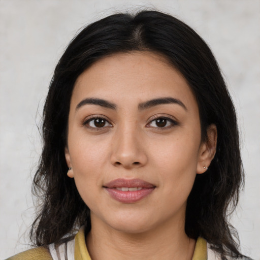 Joyful latino young-adult female with medium  brown hair and brown eyes