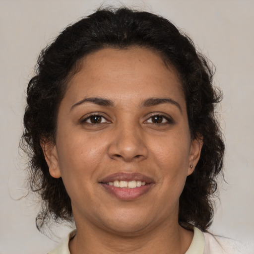 Joyful latino adult female with medium  brown hair and brown eyes