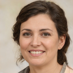 Joyful white adult female with medium  brown hair and brown eyes