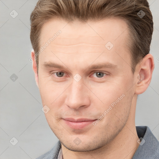 Joyful white young-adult male with short  brown hair and grey eyes